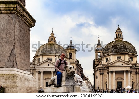 ROME, ITALY - MARCH 10 2014: Male Tourist on a Lion sculpture at the Pincio Landmark in Rome, Italy on a beautiful warm spring morning. View over the old historical and clerical buildings