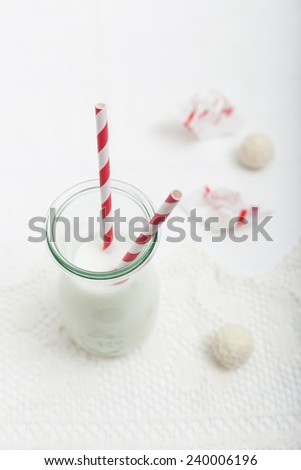 Milk in a bottle with candies in the background