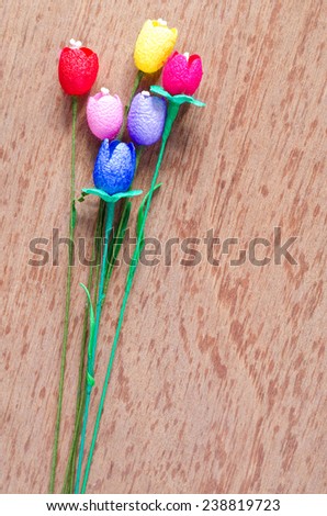 colorful artificial tulips flower made from silk cocoon on plywood background