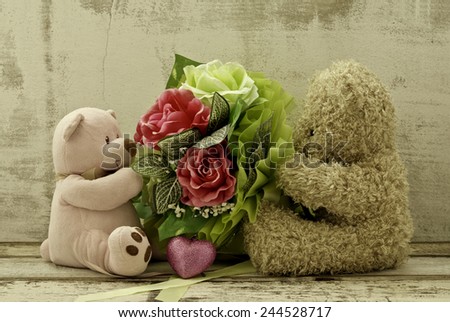 couple of cute  bears holding roses bouquet