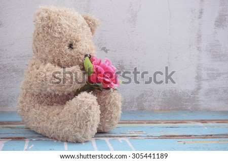 cute bear doll holding rose bouquet