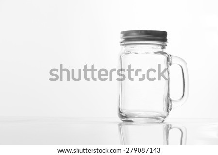 Empty vintage mason Jar  having lid and handle with on White background with reflection and copy space