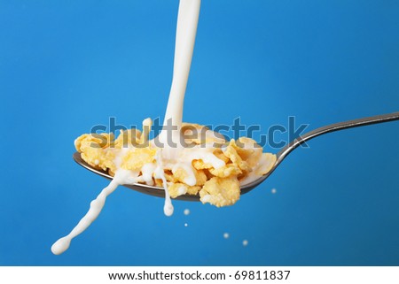 Milk Splashing Into Spoon With Cornflakes Ove