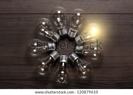 glowing bulb on wooden background uniqueness concept