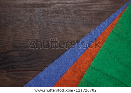 red green and blue jammed paper on wooden background