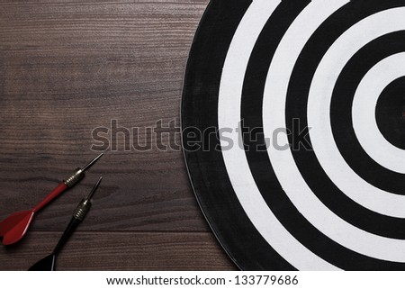 target and two darts on the wooden background