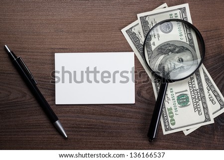 blank notebook pen and money on the wooden table