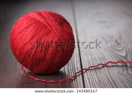 red ball of threads on wooden table