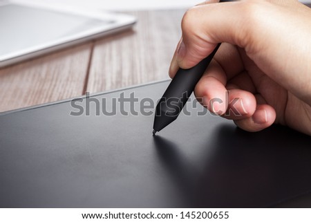 Hand Of The Designer With A Pen On Tablet