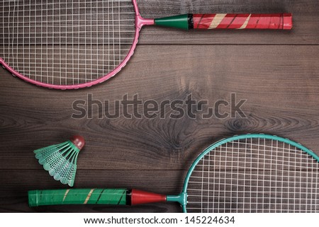 shuttlecock and badminton rackets on wooden background
