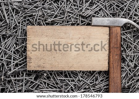 old hammer nails and wooden board on table