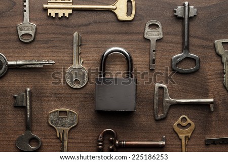 check-lock and different keys on wooden background concept