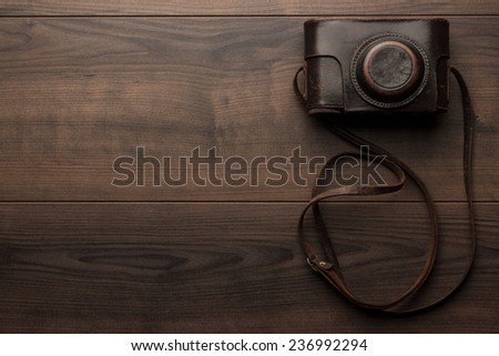 wooden background with retro still camera in case