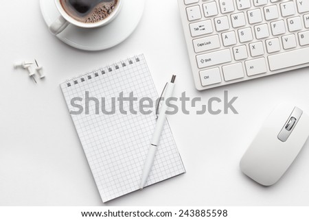 view from above on white office table with notepad, computer and coffee cup
