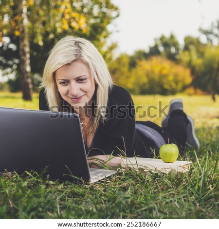 student girl with laptop studying in the park