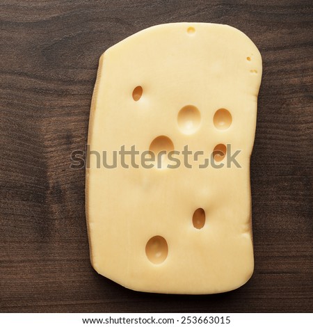 small and big pieces of cheese on wooden table