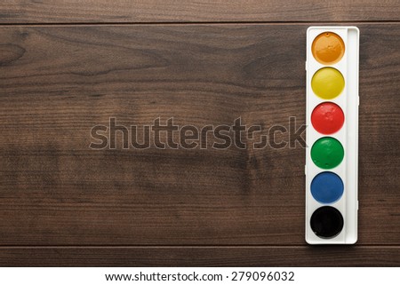 box of water paints on the wooden table