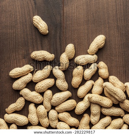 many roasted peanuts on the wooden table background