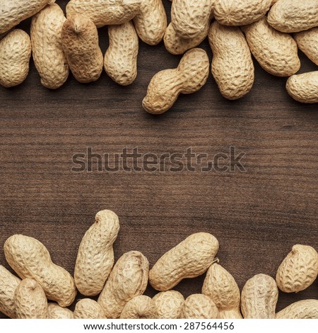 many roasted peanuts on the wooden table background with copy space