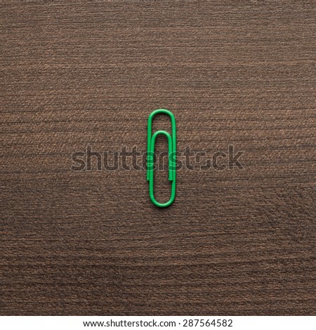 bright green paper clip on the wooden table