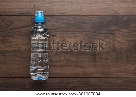 plastic water bottle with blue cap on the wooden table