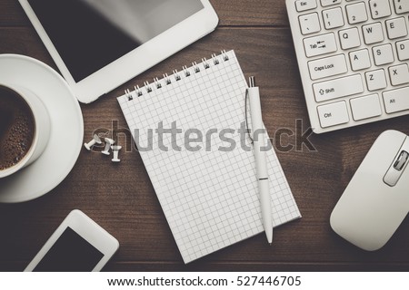 overhead of office table with notebook, computer keyboard and mouse, tablet pc and smartphone