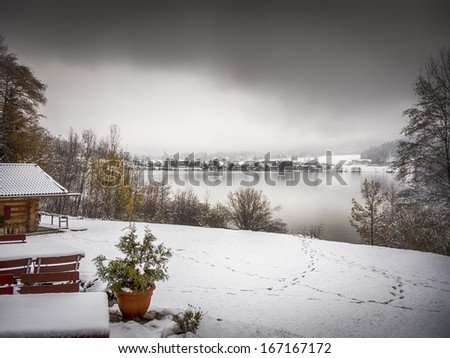 Lake Schliersee with dark clouds and white winter snow in Bavaria, Germany
