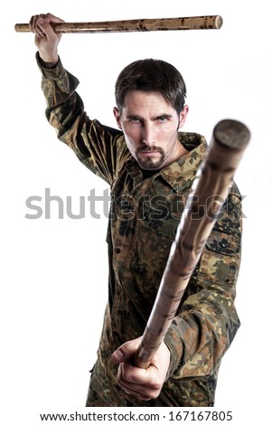 Male self defense instructor with camouflage do a self defense exercise with bamboo sticks, isolated on white background