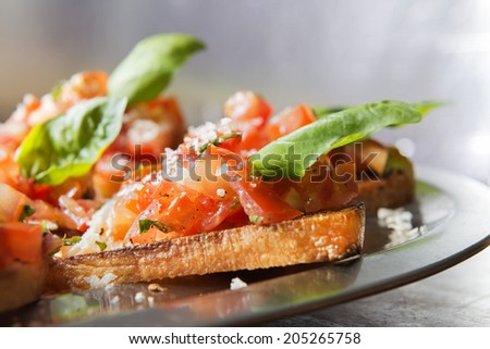 Close-up image of italian bruschetta with tomatoe and basil on a serving plate