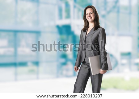 Business woman in gray suit in front of an office building
