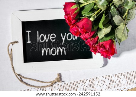 Image of a slate blackboard with message I love you mom and red roses