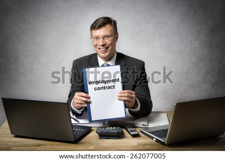 Businessman at the office desk is holding a employment contract