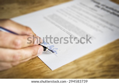 Image of a hand that signs a business contract
