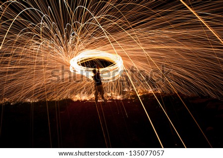 Light painting, spinning lit steel wool in an open field