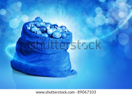 Blue christmas balls and toys in Santa bag on abstract background