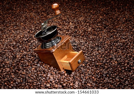 Old hand grinder on coffee beans. Background concept