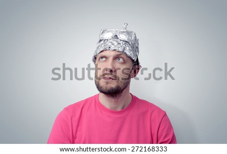 Bearded funny man in a cap of aluminum foil. Concept art phobias