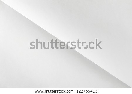 white sheet of paper folded in two diagonally with texture.