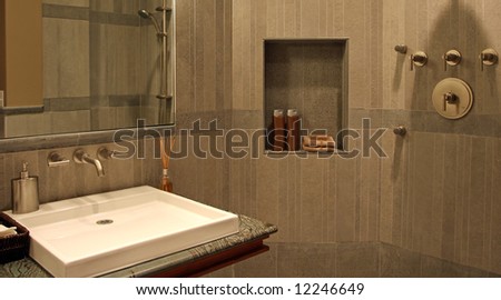 A very modern bathroom with stone walls and a flat sink.