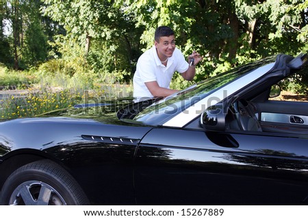 A teenage boy holding the keys to an expensive convertible hoping to drive.