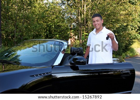A teenage boy holding the keys to an expensive convertible hoping to drive.
