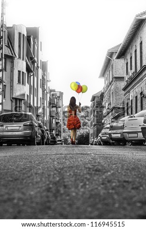 Beautiful woman in red clothes on a black-white city hot-air balloon in the background