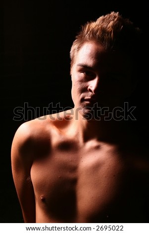 Profile of a young muscular man staring into the camera in color