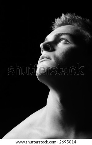 Profile of a young man staring dreamfully upwards in black and white