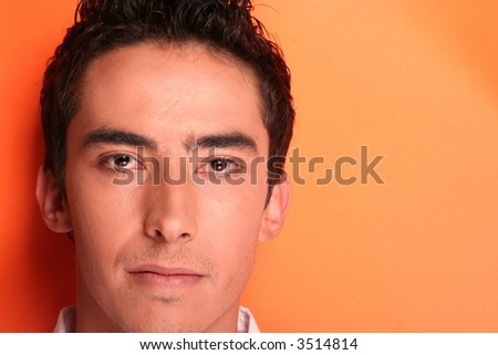 Young mans face on orange background