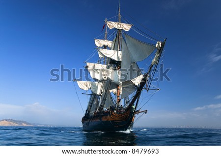 HMS Surprise Sailing Ship at Sea under full sail with tall ships in the background.