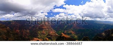 A view into Waimea Canyon with lush green trees and red cliffs