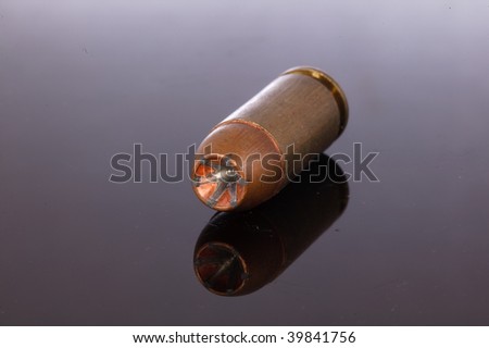 9mm Hollow Point bullet on a black background with reflection