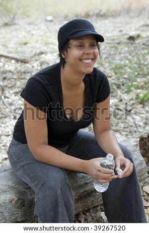 light skinned african-american woman taking a playful rest with a bottle of water
