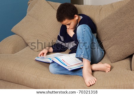 Young middle school student studying intensely in his notebook.